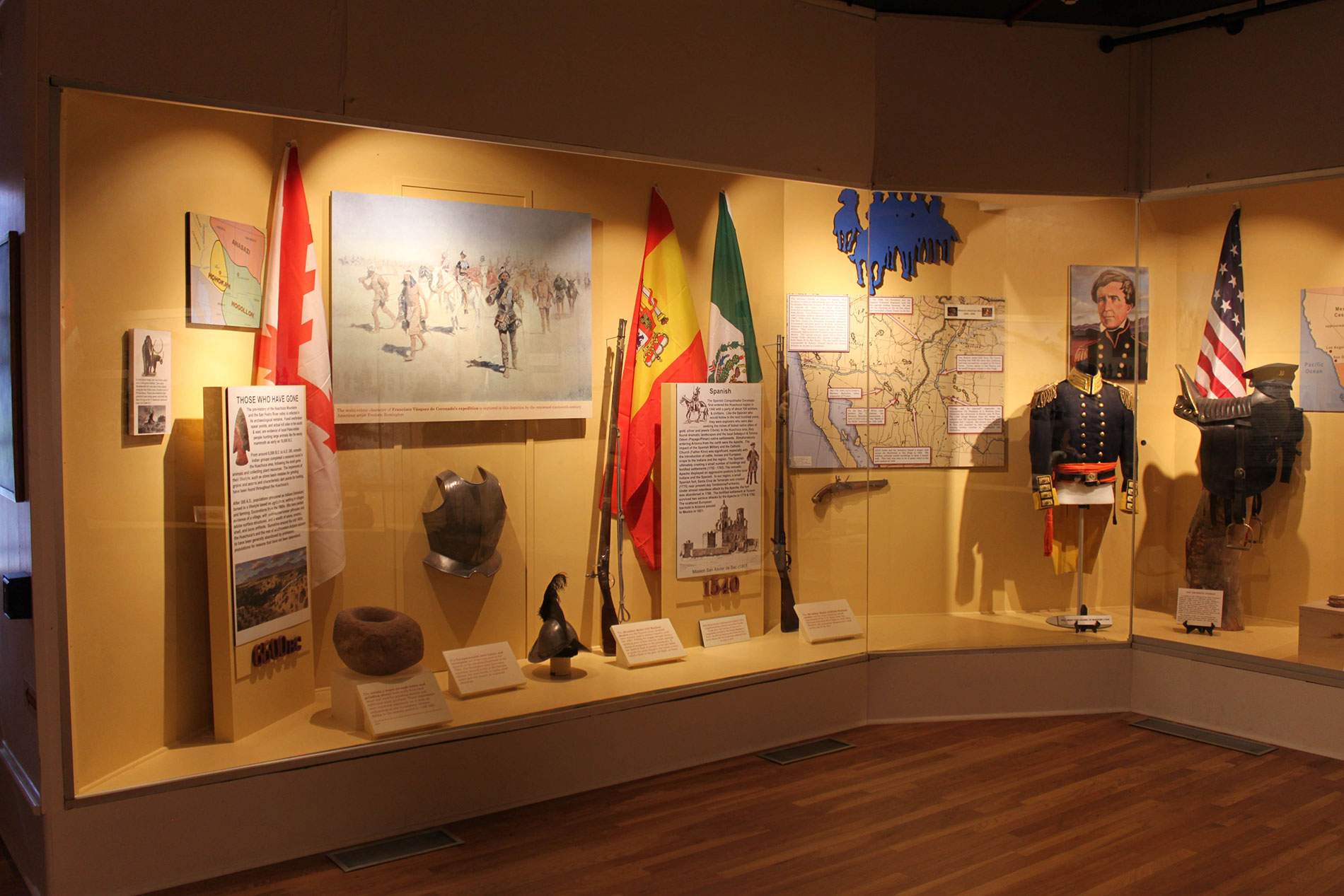 Corner museum display with several artifacts inside glass enclosure_A.